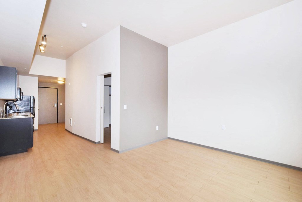 a living room with a hardwood floor and white walls
