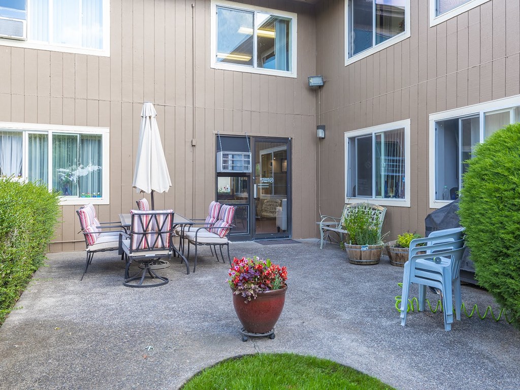 a patio with chairs and tables outside of a building