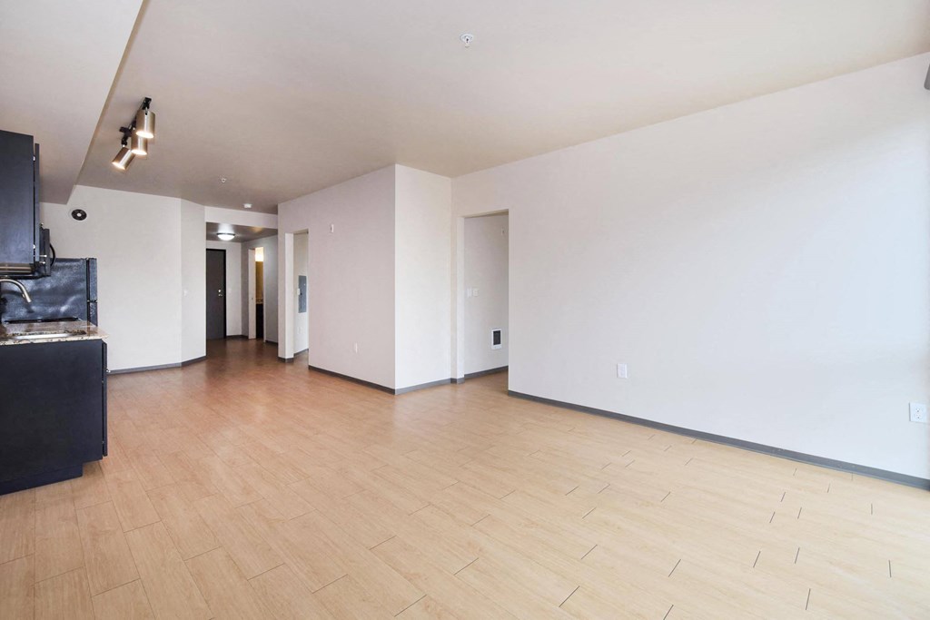 a living room with white walls and hardwood floors