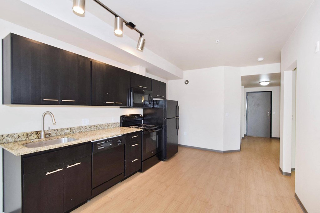a kitchen with dark cabinets and a wooden floor