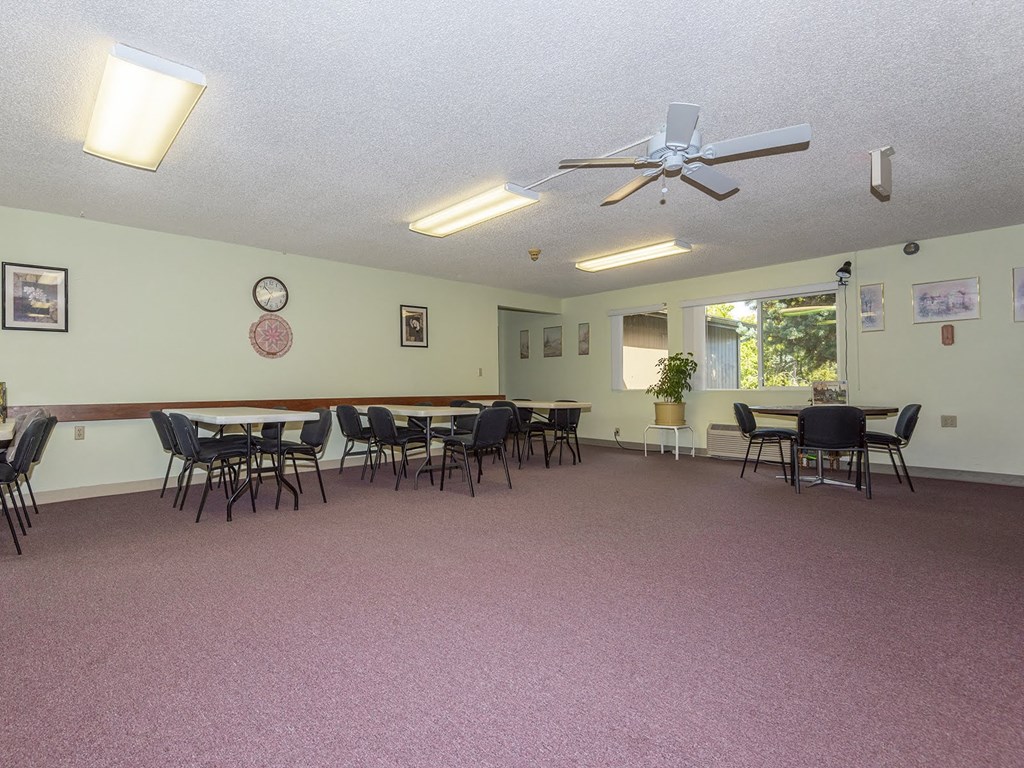 a conference room with tables and chairs and a ceiling fan