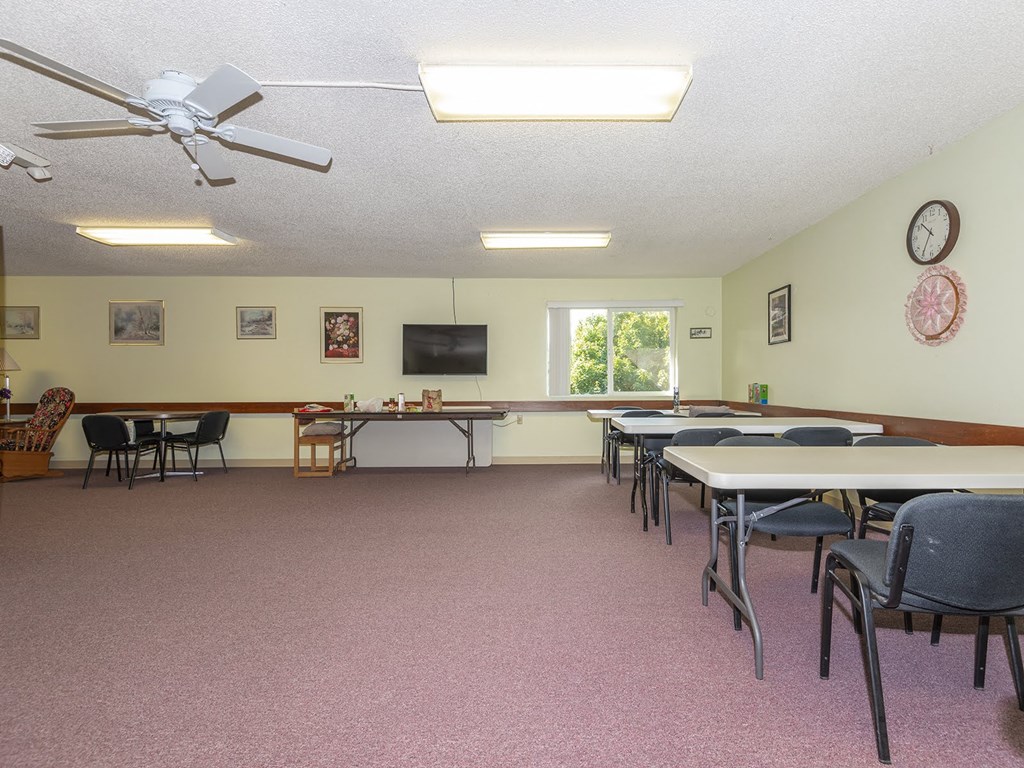 a conference room with tables and chairs and a ceiling fan