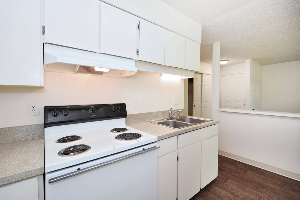 a kitchen with white cabinets and a white stove top oven