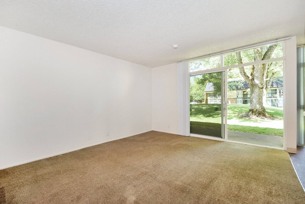 a bedroom with a large window and white walls