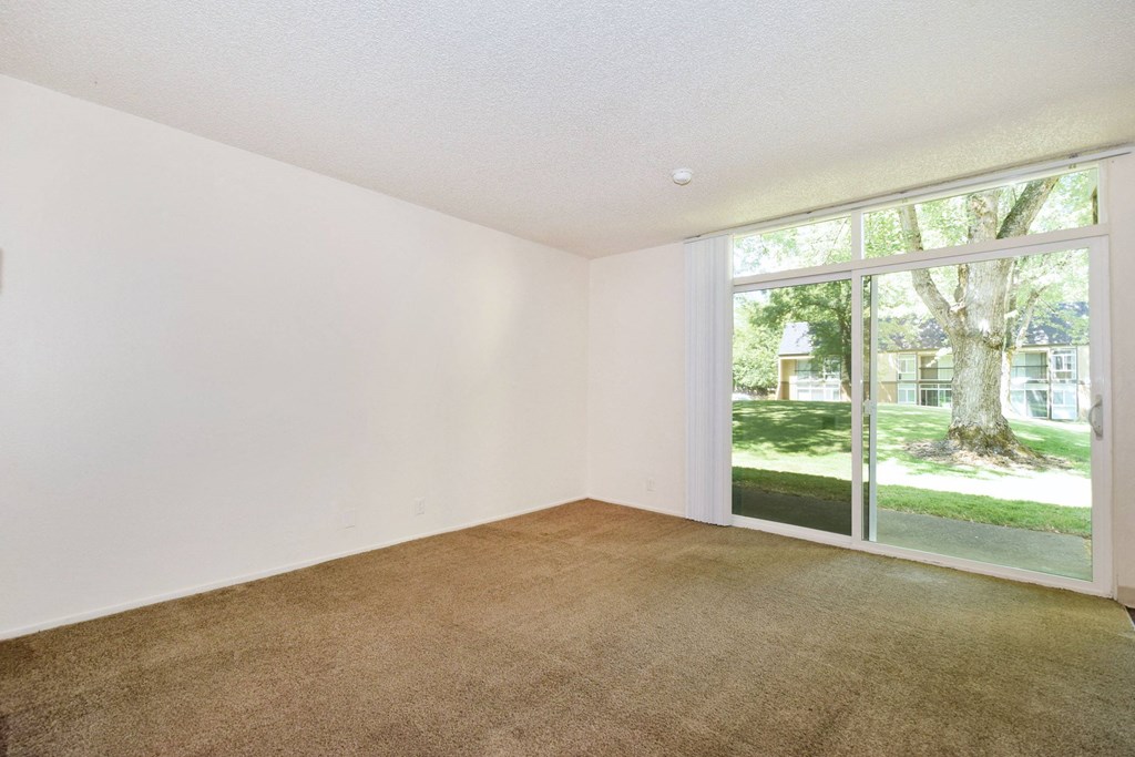 a bedroom with a large window and white walls