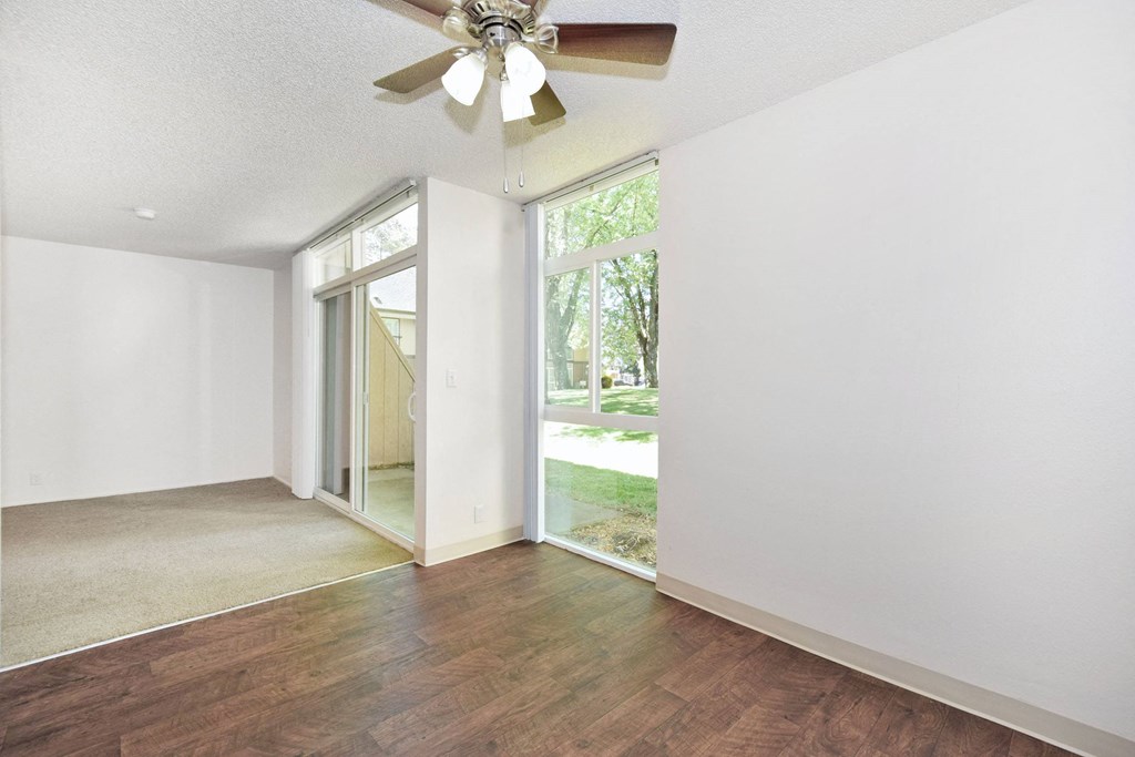 a bedroom with white walls and a ceiling fan