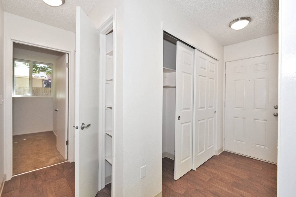 a bedroom with two closets and a bathroom in the background