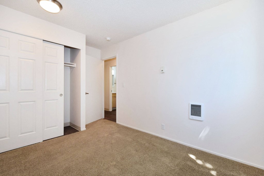 a bedroom with white walls and carpet