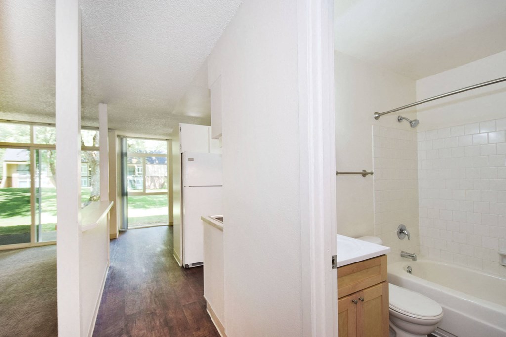 a bathroom with a white toilet next to a white tub