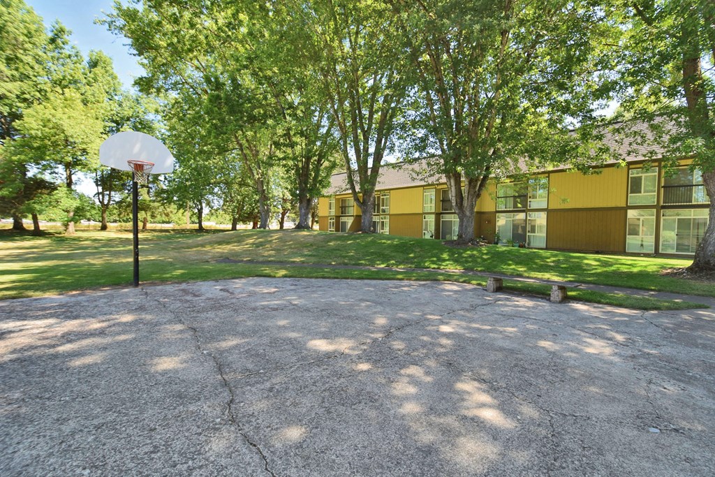 a basketball court in front of a yellow building