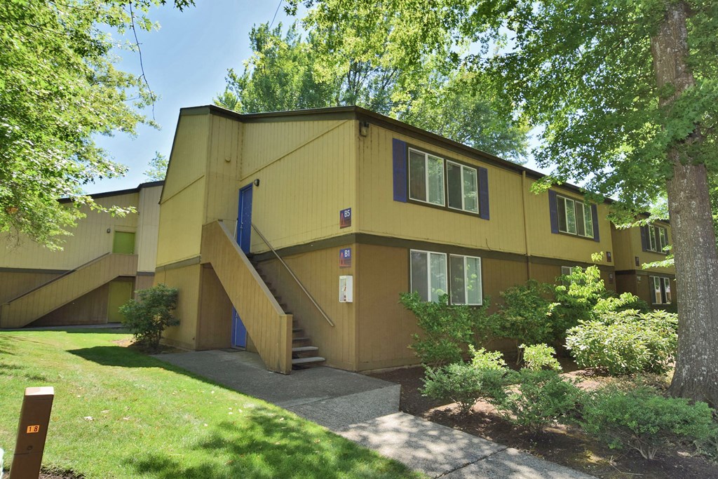 a yellow house with a blue door and stairs