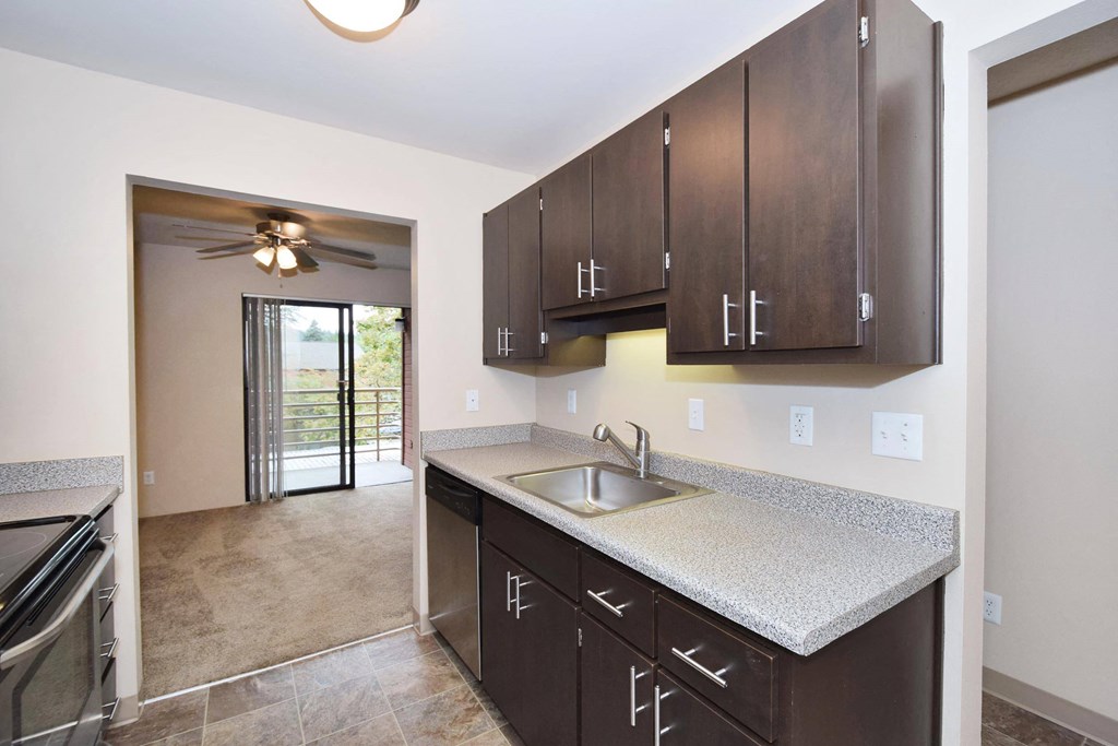 a kitchen with dark cabinets and a ceiling fan