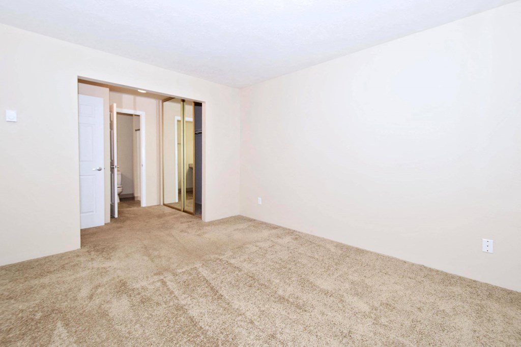 a bedroom with white walls and carpet
