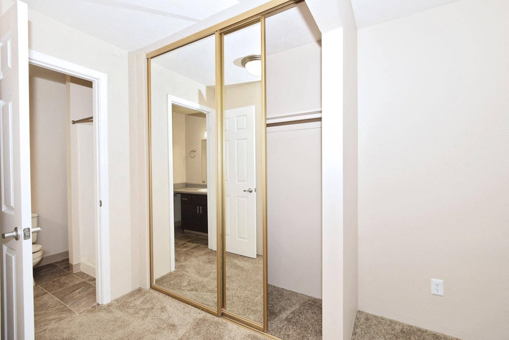 a mirror in a bedroom with a bathroom in the background