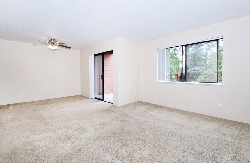 a bedroom with a ceiling fan and a large window
