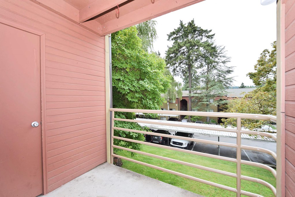 a balcony with a door and a grassy area