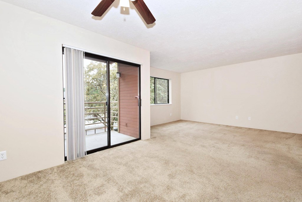 a bedroom with a ceiling fan and a sliding glass door to a balcony