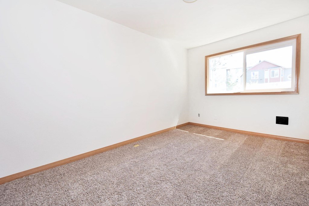 a bedroom with white walls and a large window