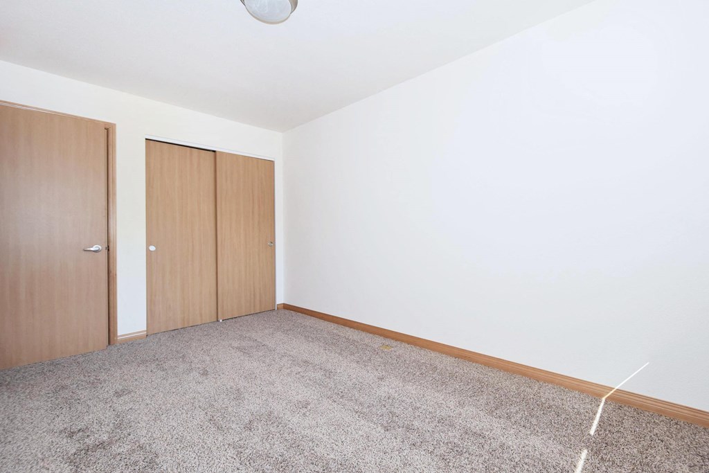a bedroom with white walls and a carpeted floor