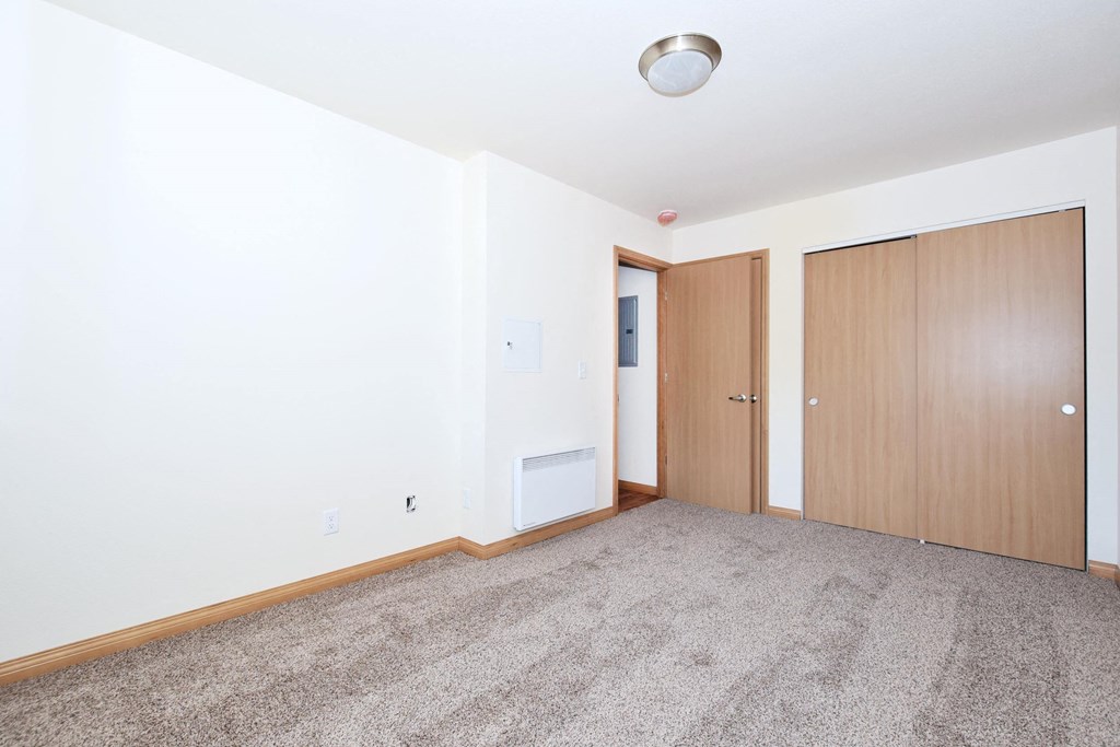 a bedroom with two doors and a carpeted floor