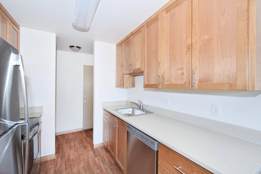 a kitchen with wooden cabinets and a stainless steel refrigerator