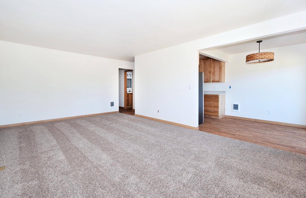 a living room with white walls and hardwood floors