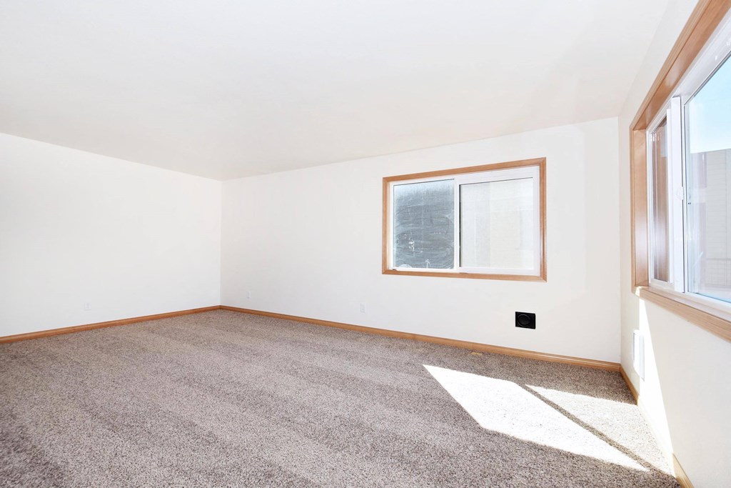 a bedroom with white walls and a large window