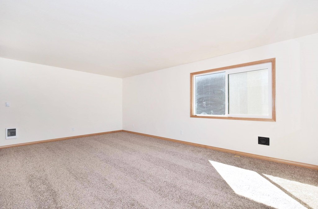 a bedroom with white walls and a window