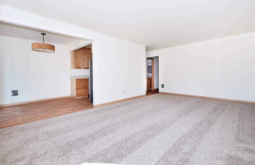 a living room with white walls and hardwood floors