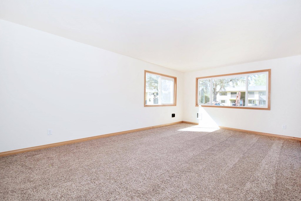 a bedroom with white walls and a large window