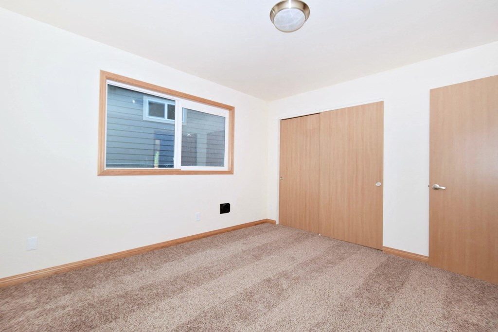 a bedroom with a window and a door