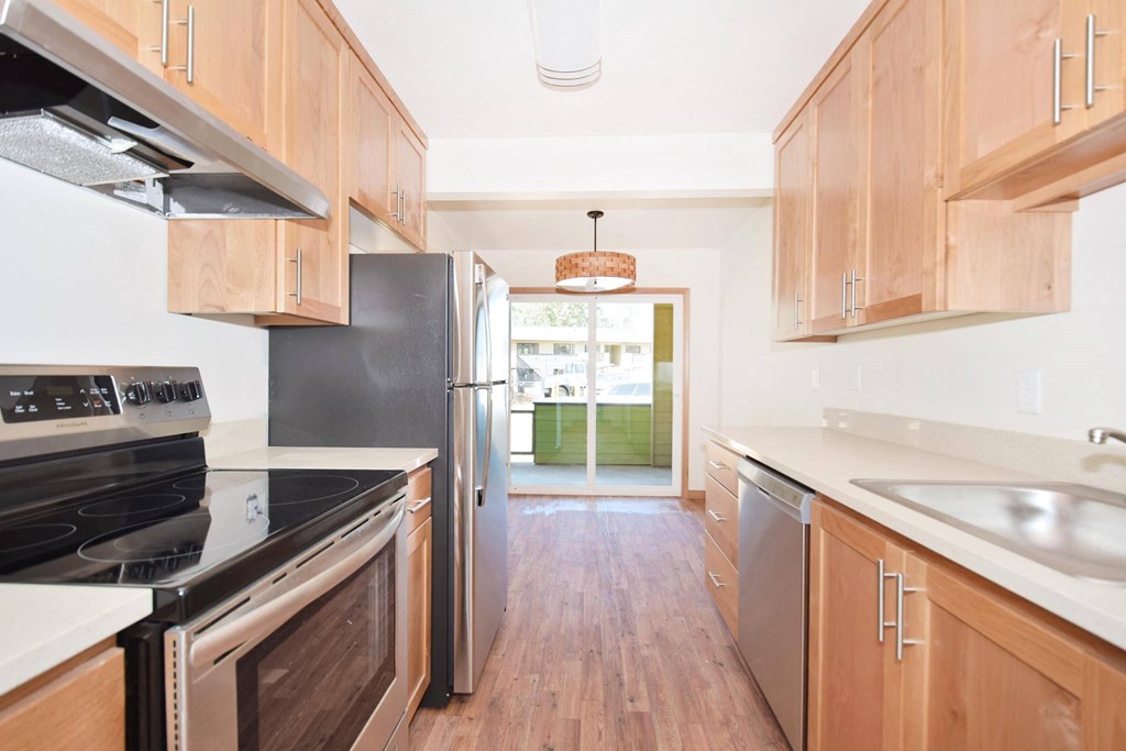 a kitchen with wooden cabinets and stainless steel appliances