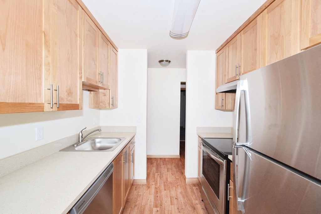 a kitchen with wooden cabinets and stainless steel appliances