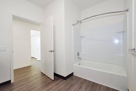a white bathroom with a shower and a tub in a room