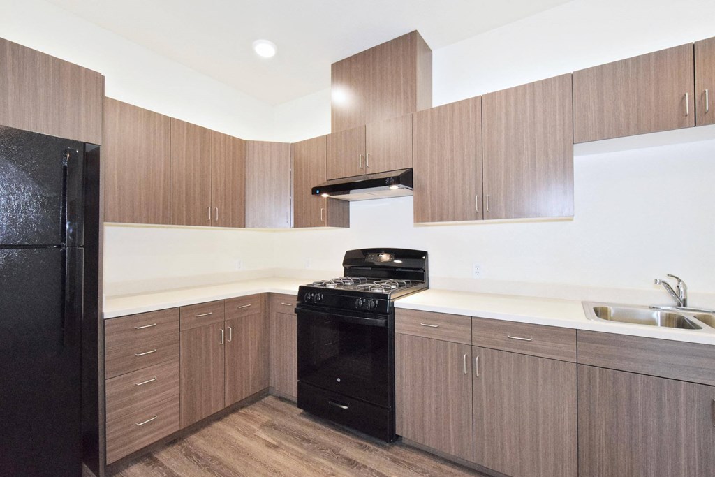 a kitchen with wooden cabinets and a black stove top oven