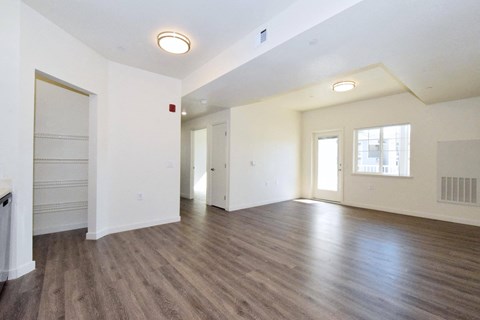 an empty living room with white walls and wood flooring