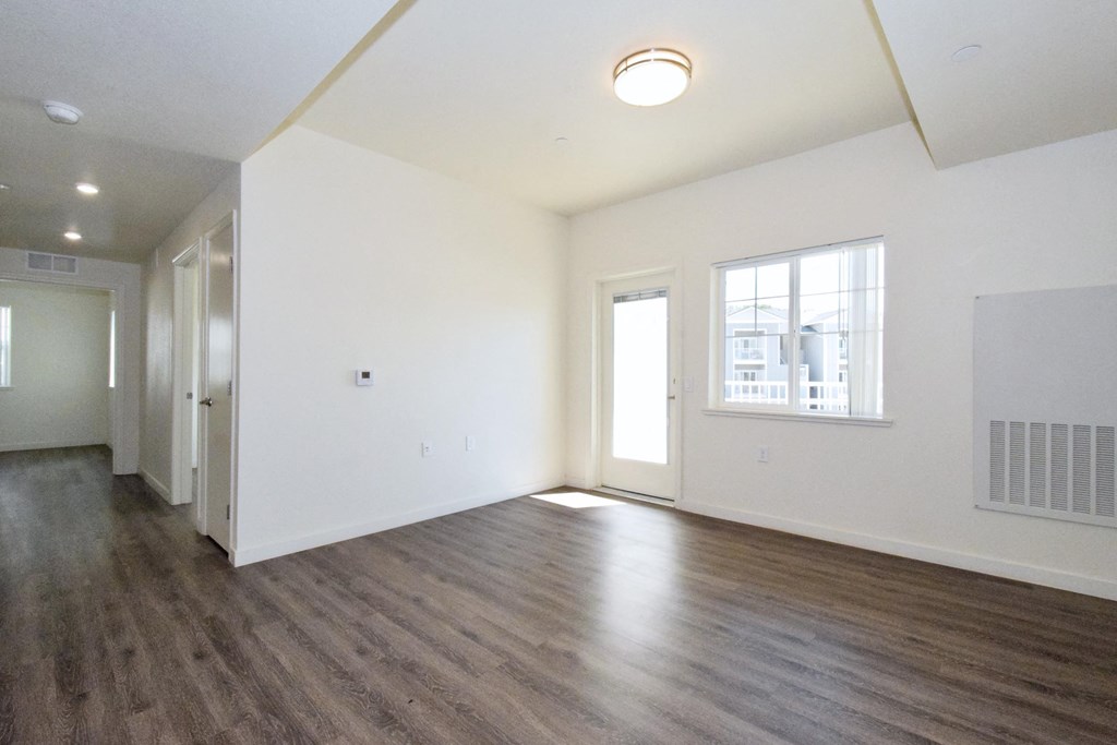 an empty room with white walls and a wooden floor