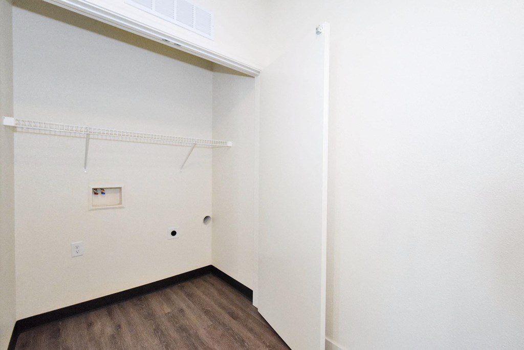 a bedroom with white walls and a wooden floor