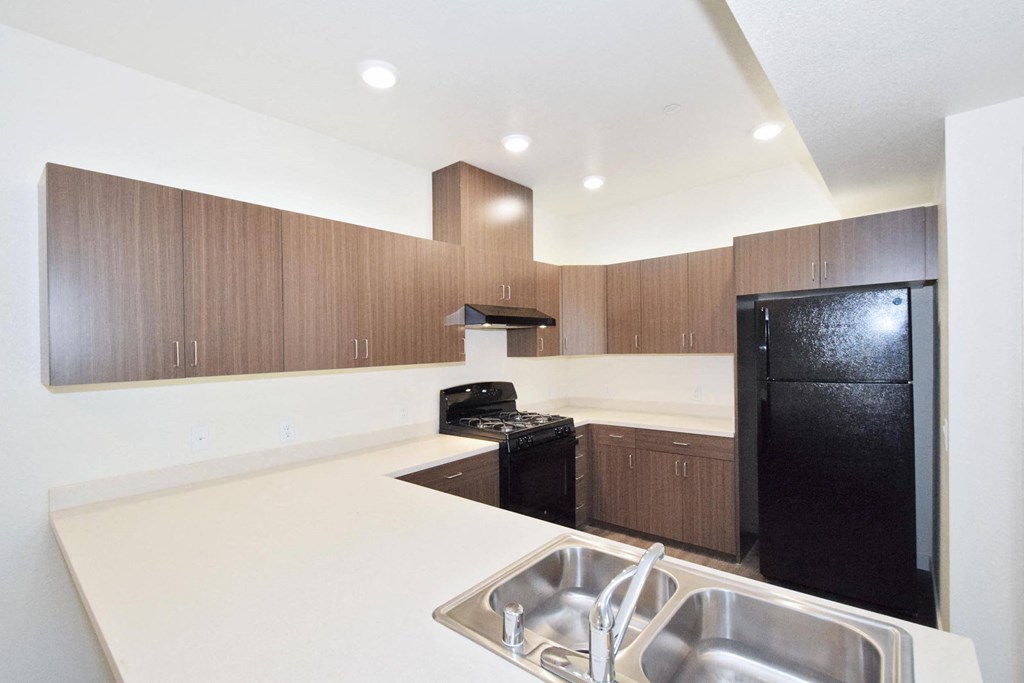 a kitchen with white countertops and black appliances