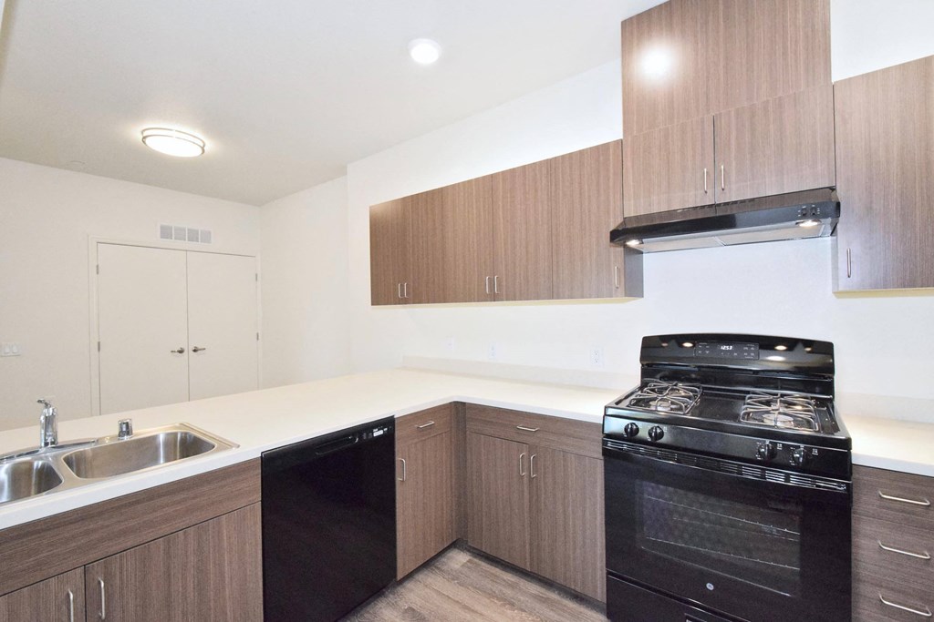 a kitchen with wooden cabinets and black appliances