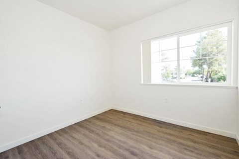 an empty room with white walls and a window