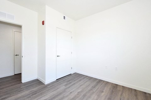 an empty room with white walls and wood floors