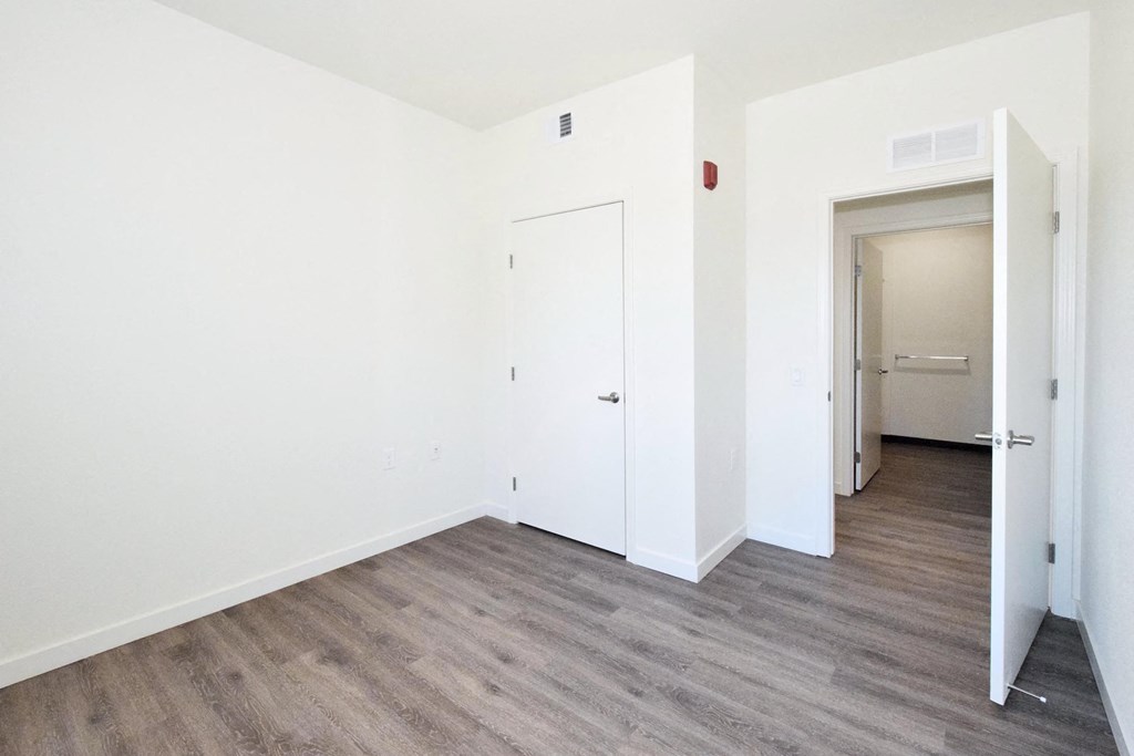 an empty room with white walls and a wood floor