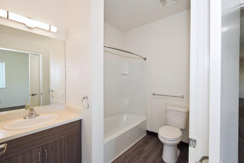 a white bathroom with a shower and a sink and a toilet