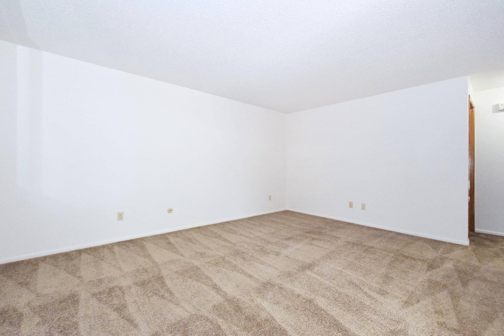 an empty room with a carpeted floor and white walls