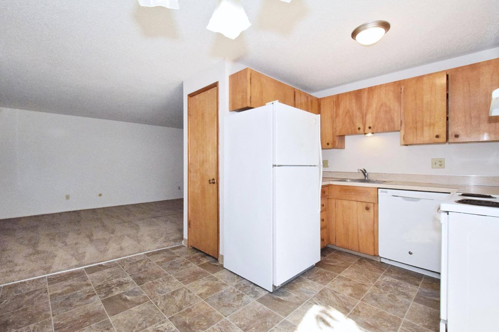 a kitchen with white appliances and wooden cabinets