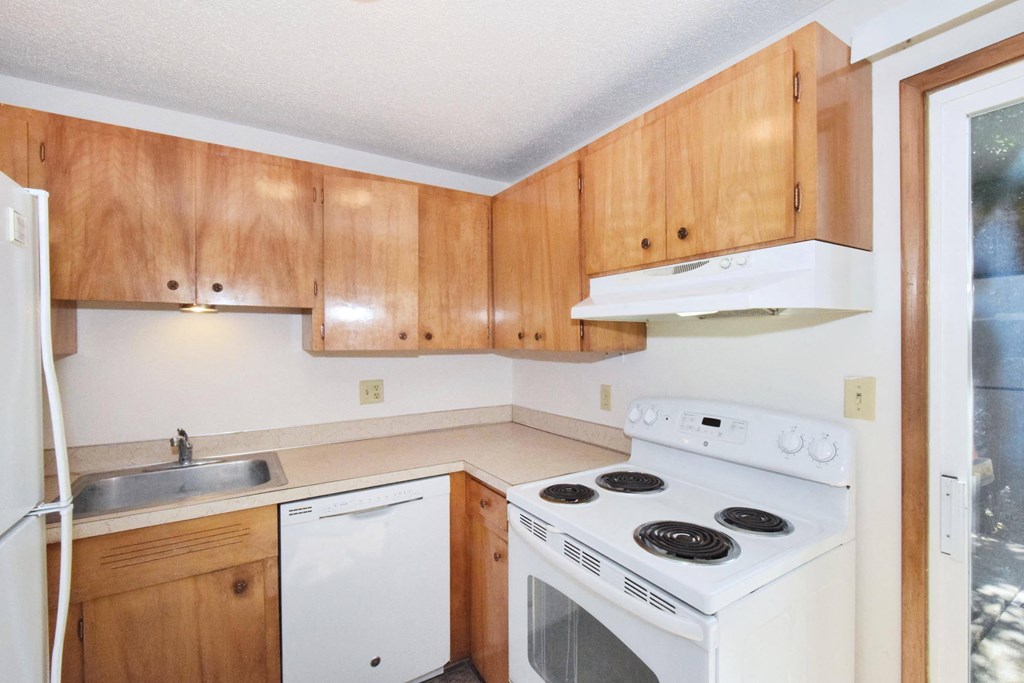a kitchen with wooden cabinets and white appliances