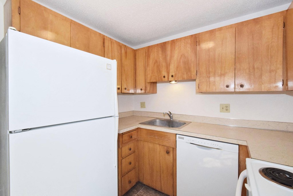 a kitchen with white appliances and wooden cabinets