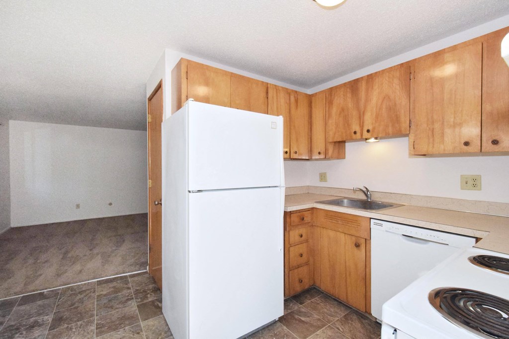 a kitchen with white appliances and wooden cabinets