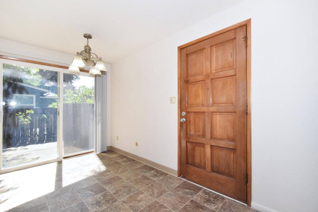 a bedroom with a large wooden door and a sliding glass door leading to a patio